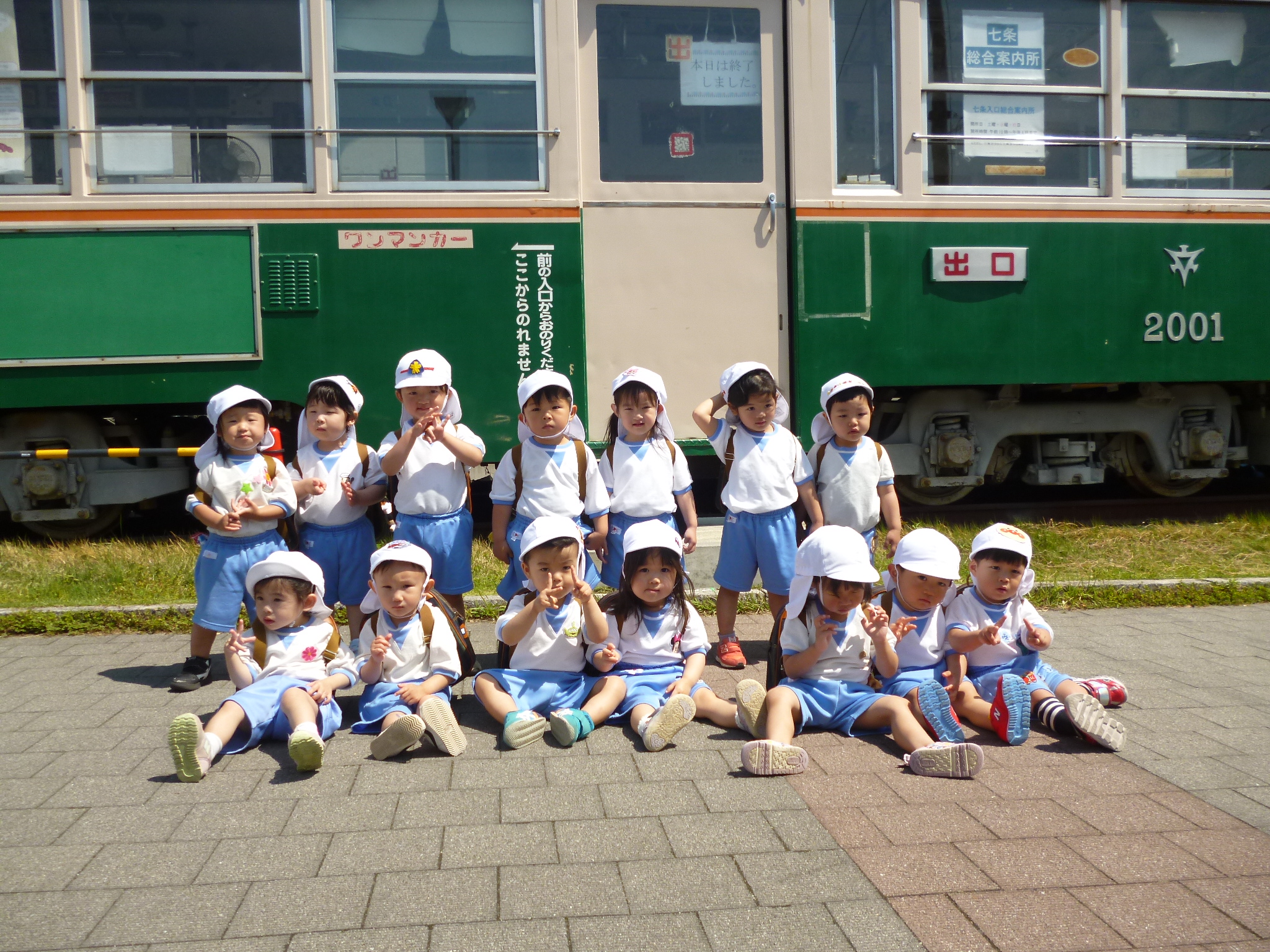電車の前ではい、ポーズ！（きりん、２歳児）